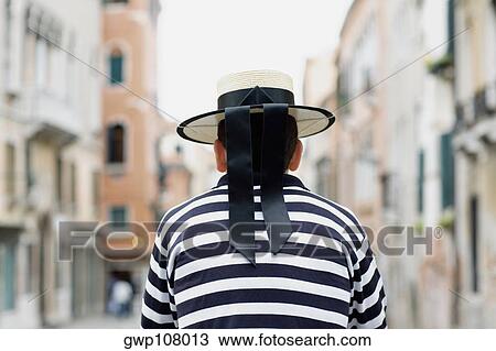 Rear view of a gondolier standing wearing a hat, Venice, Veneto, Italy View Large Photo Image Stock Image - Rear view of a gondolier standing wearing a hat, Venice, Veneto, Italy. Fotosearch