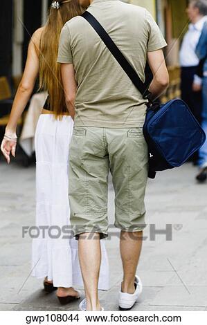 Rear view of a man and a woman walking View Large Photo Image Picture - Rear view of a man and a woman walking. Fotosearch