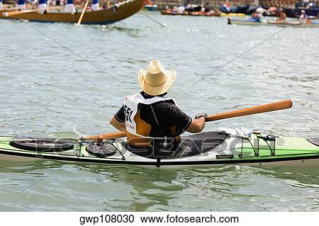Stock Image - Rear view of a man kayaking, Venice, Veneto, Italy. Fotosearch