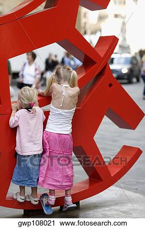 Rear view of two girls climbing a rocking horse sculpture, Venice, Veneto, Italy View Large Photo Image Stock Image - Rear view of two girls climbing a rocking horse sculpture, Venice, Veneto, Italy. Fotosearch