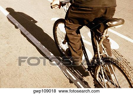 Low section view of a man cycling View Large Photo Image Stock Photo - Low section view of a man cycling. Fotosearch