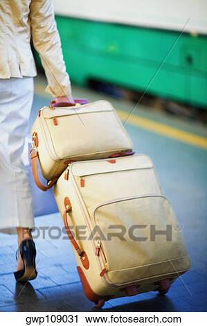 Low section view of a woman pulling luggage at railroad station platform, Rome, Italy View Large Photo Image Stock Image - Low section view of a woman pulling luggage at railroad station platform, Rome, Italy. Fotosearch