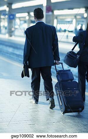 Rear view of a man and a woman walking at a railroad station, Rome, Italy View Large Photo Image Stock Image - Rear view of a man and a woman walking at a railroad station, Rome, Italy. Fotosearch