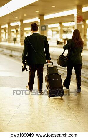 Rear view of a man and a woman walking at a railroad station, Rome, Italy View Large Photo Image Stock Photo - Rear view of a man and a woman walking at a railroad station, Rome, Italy. Fotosearch