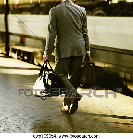 Rear view of a man walking at a railroad station platform, Rome, Italy View Large Photo Image Picture - Rear view of a man walking at a railroad station platform, Rome, Italy. Fotosearch