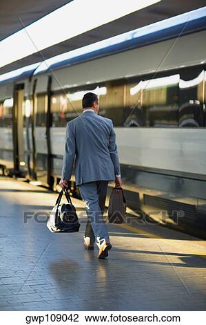 Rear view of a man walking at a railroad station platform, Rome, Italy View Large Photo Image Stock Image - Rear view of a man walking at a railroad station platform, Rome, Italy. Fotosearch