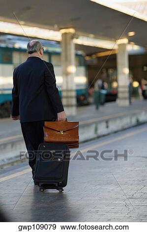 Rear view of a man walking at a railroad station platform, Rome, Italy View Large Photo Image Stock Photo - Rear view of a man walking at a railroad station platform, Rome, Italy. Fotosearch