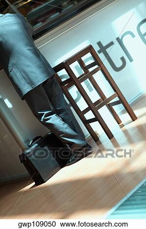 Rear view of a person standing with a briefcase beside him, Madrid, Spain View Large Photo Image Stock Image - Rear view of a person standing with a briefcase beside him, Madrid, Spain. Fotosearch