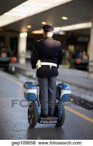 Rear view of a policeman on a scooter at a railroad station platform, Rome, Italy View Large Photo Image Stock Photo - Rear view of a policeman on a scooter at a railroad station platform, Rome, Italy. Fotosearch