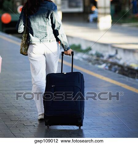 Rear view of a woman pulling her luggage at a railroad station platform, Rome, Italy View Large Photo Image Stock Image - Rear view of a woman pulling her luggage at a railroad station platform, Rome, Italy. Fotosearch