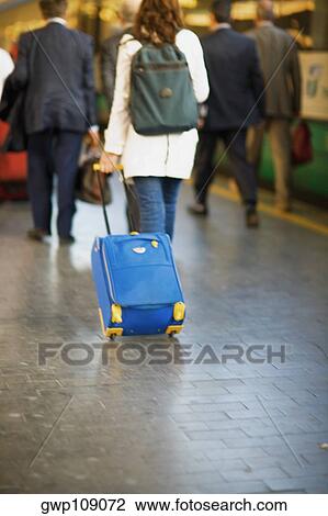 Stock Image - Rear view of a woman walking at a railroad station platform, Rome, Italy. Fotosearch