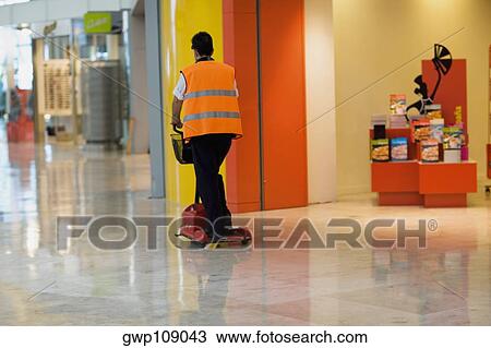 Rear view of an airport worker using a push scooter, Madrid, Spain View Large Photo Image Stock Image - Rear view of an airport worker using a push scooter, Madrid, Spain. Fotosearch