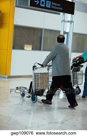 Side profile of a person pushing a luggage cart, Madrid, Spain View Large Photo Image Stock Photograph - Side profile of a person pushing a luggage cart, Madrid, Spain. Fotosearch