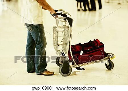 Side profile of a person standing near a luggage cart, Madrid, Spain View Large Photo Image Stock Image - Side profile of a person standing near a luggage cart, Madrid, Spain. Fotosearch