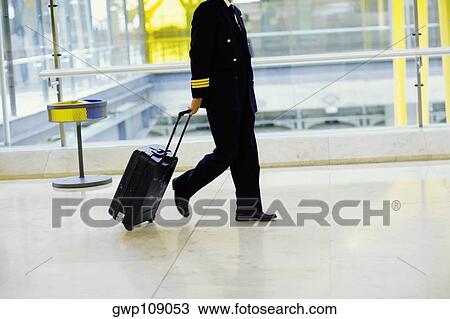 Side profile of a pilot pulling luggage at an airport, Madrid, Spain View Large Photo Image Stock Image - Side profile of a pilot pulling luggage at an airport, Madrid, Spain. Fotosearch