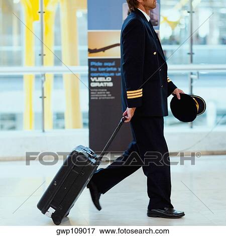 Side profile of a pilot pulling luggage at an airport, Madrid, Spain View Large Photo Image Stock Photo - Side profile of a pilot pulling luggage at an airport, Madrid, Spain. Fotosearch