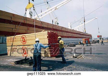 Workers unloading a shipment of treated lumber View Large Photo Image Stock Photography - Workers unloading a shipment of treated lumber. Fotosearch