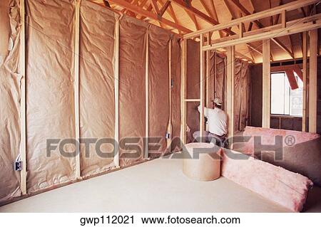 Installing insulation into wall of new home View Large Photo Image Stock Image - Installing insulation into wall of new home. Fotosearch