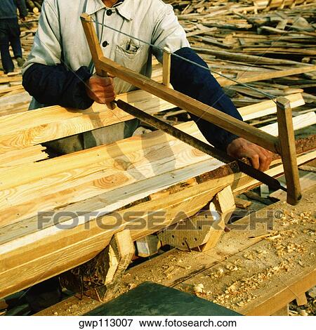 Mid section view of a carpenter sawing a plank, China View Large Photo Image Stock Photo - Mid section view of a carpenter sawing a plank, China. Fotosearch