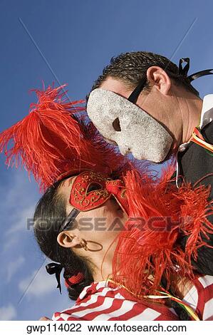 Low angle view of a man and woman wearing masks and looking at each other View Large Photo Image Stock Image - Low angle view of a man and woman wearing masks and looking at each other. Fotosearch