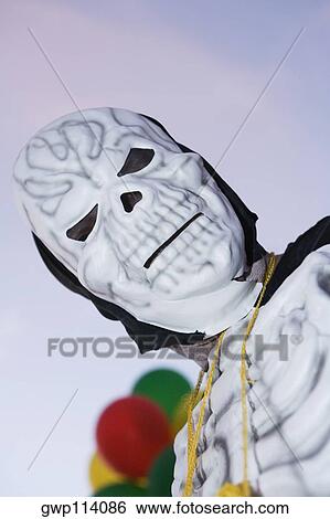 Low angle view of a man wearing a mask View Large Photo Image Stock Photograph - Low angle view of a man wearing a mask. Fotosearch