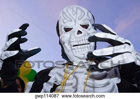 Low angle view of a man wearing a costume and a mask View Large Photo Image Stock Photo - Low angle view of a man wearing a costume and a mask. Fotosearch