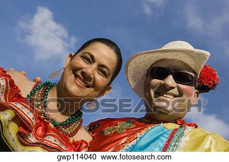 Stock Image - Low angle view of a mature couple wearing costumes and smiling. Fotosearch
