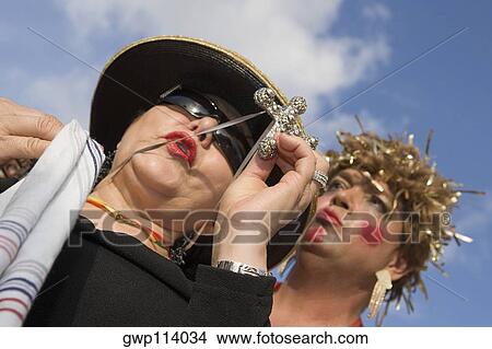 Low angle view of a mature woman holding a cross with a mature man behind her View Large Photo Image Picture - Low angle view of a mature woman holding a cross with a mature man behind her. Fotosearch