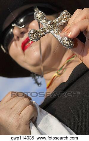 Low angle view of a mature woman holding a cross View Large Photo Image Stock Photography - Low angle view of a mature woman holding a cross. Fotosearch
