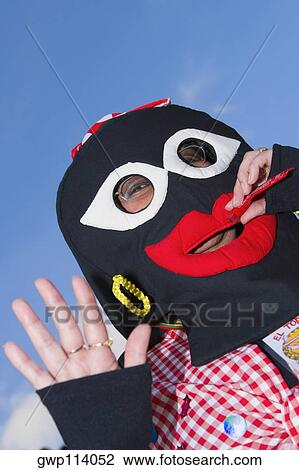 Low angle view of a person wearing masks View Large Photo Image Stock Image - Low angle view of a person wearing masks. Fotosearch
