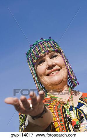Portrait of a senior woman wearing a beaded headdress and smiling View Large Photo Image Stock Photo - Portrait of a senior woman wearing a beaded headdress and smiling. Fotosearch