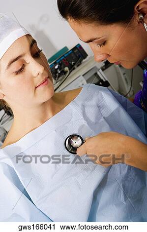 Close-up of a female doctor examining a female patient with a stethoscope View Large Photo Image Stock Image - Close-up of a female doctor examining a female patient with a stethoscope. Fotosearch