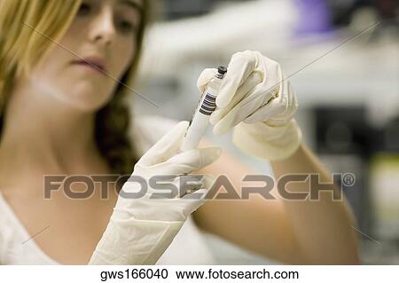 Stock Image - Close-up of a female nurse holding a syringe. Fotosearch