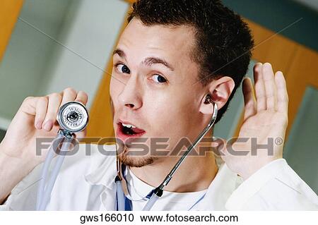 Close-up of a male doctor listening with a stethoscope View Large Photo Image Stock Image - Close-up of a male doctor listening with a stethoscope. Fotosearch