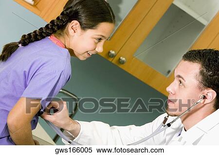Male doctor examining a girl with a stethoscope View Large Photo Image Stock Photography - Male doctor examining a girl with a stethoscope. Fotosearch