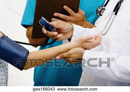 Mid section view of a male doctor measuring blood pressure of a female patient View Large Photo Image Stock Image - Mid section view of a male doctor measuring blood pressure of a female patient. Fotosearch