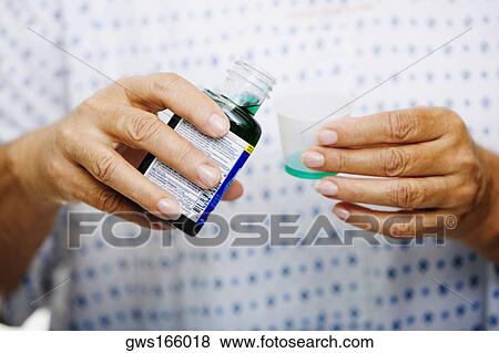 Stock Photo - Mid section view of a woman pouring syrup in to a measuring cup. Fotosearch