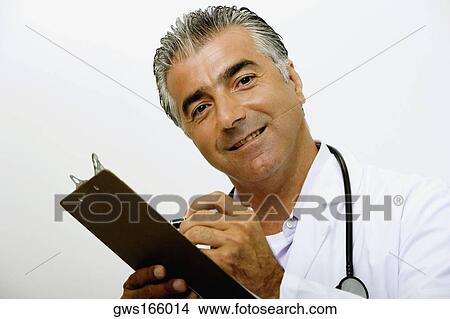 Portrait of a male doctor writing on a clipboard and smiling View Large Photo Image Picture - Portrait of a male doctor writing on a clipboard and smiling. Fotosearch