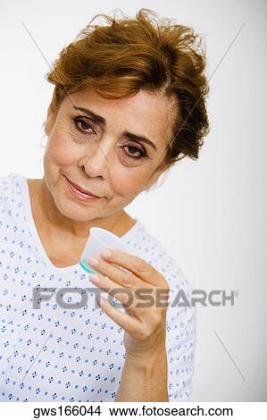 Portrait of a senior woman taking syrup from a measuring cup View Large Photo Image Picture - Portrait of a senior woman taking syrup from a measuring cup. Fotosearch