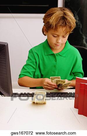 Stock Image - Boy counting currency notes. Fotosearch