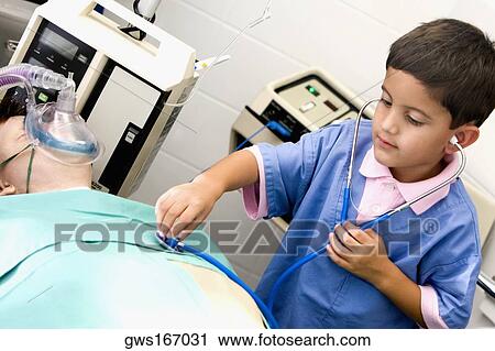 Boy imitating a doctor and examining a patient with a stethoscope View Large Photo Image Stock Image - Boy imitating a doctor and examining a patient with a stethoscope. Fotosearch