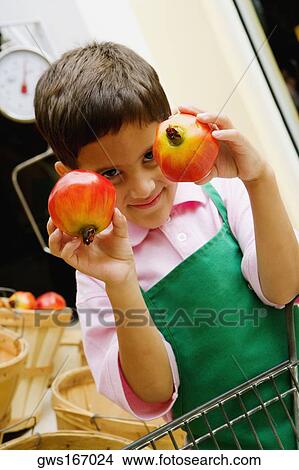 Close-up of a boy showing two pomegranates View Large Photo Image Picture - Close-up of a boy showing two pomegranates. Fotosearch