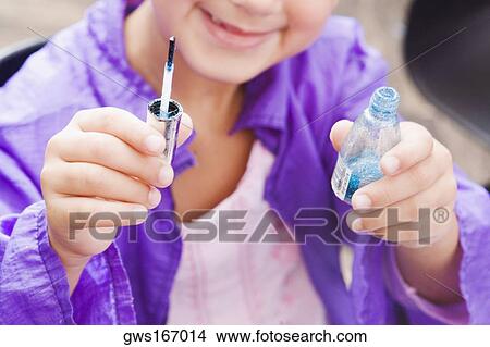 Close-up of a girl holding a nail polish bottle View Large Photo Image Picture - Close-up of a girl holding a nail polish bottle. Fotosearch