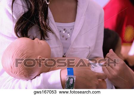 Close-up of a woman carrying a doll View Large Photo Image Stock Image - Close-up of a woman carrying a doll. Fotosearch