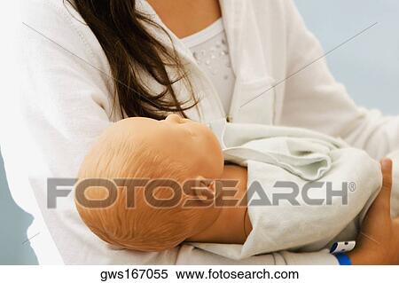 Close-up of a woman carrying a doll View Large Photo Image Stock Photography - Close-up of a woman carrying a doll. Fotosearch