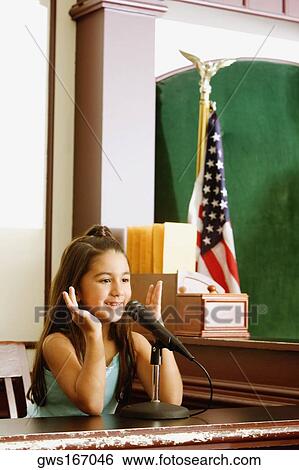 Girl imitating a witness sitting in a witness stand View Large Photo Image Stock Photograph - Girl imitating a witness sitting in a witness stand. Fotosearch