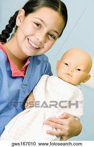Portrait of a girl carrying a doll and smiling View Large Photo Image Stock Image - Portrait of a girl carrying a doll and smiling. Fotosearch