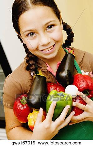 Portrait of a girl holding vegetables and smiling View Large Photo Image Stock Photo - Portrait of a girl holding vegetables and smiling. Fotosearch