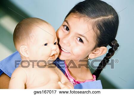 Stock Photo - Portrait of a girl playing with a doll. Fotosearch
