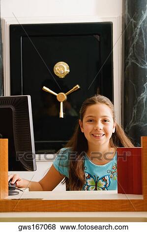 Stock Photo - Portrait of a girl sitting in front of a safe. Fotosearch